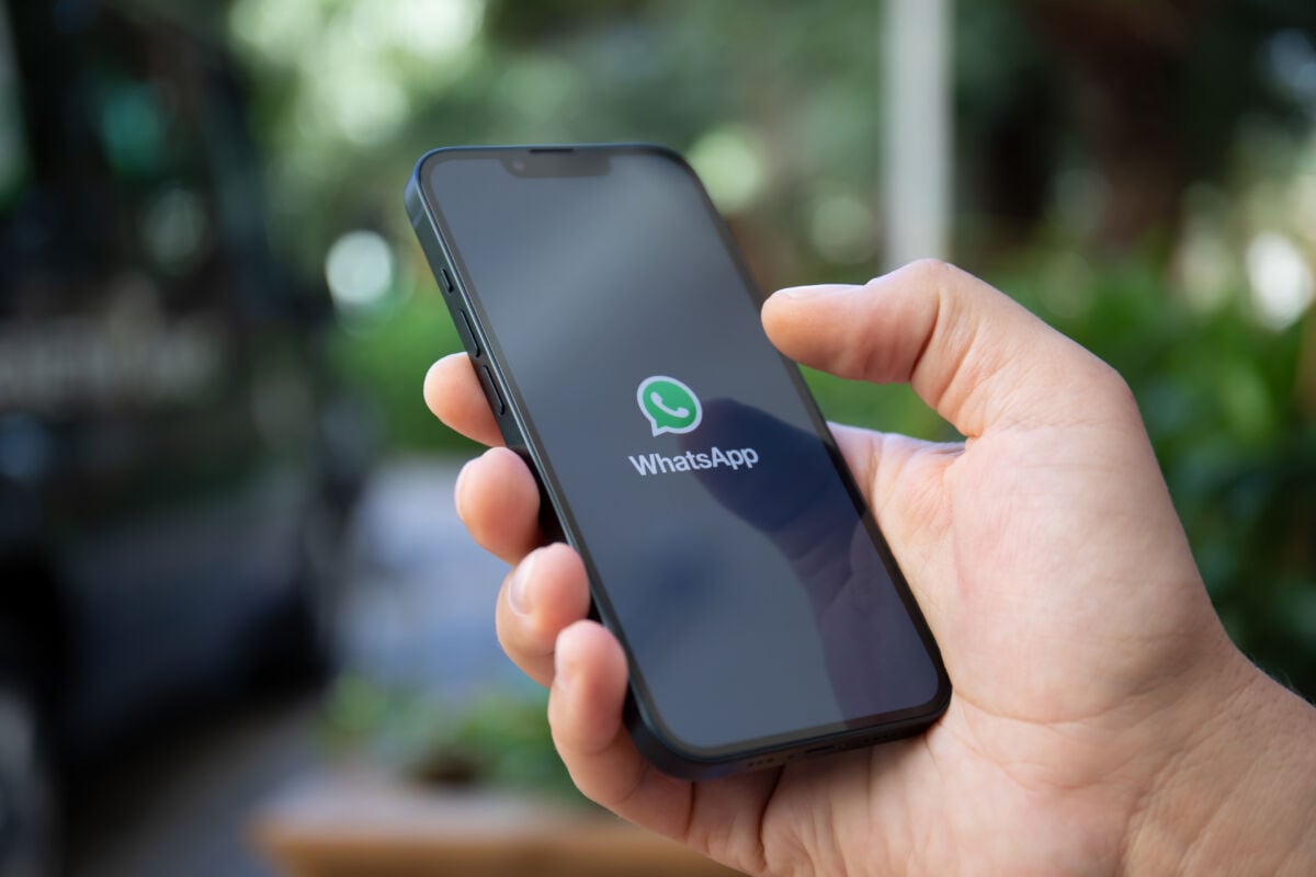 uomo che tiene in mano smartphone con whatsapp