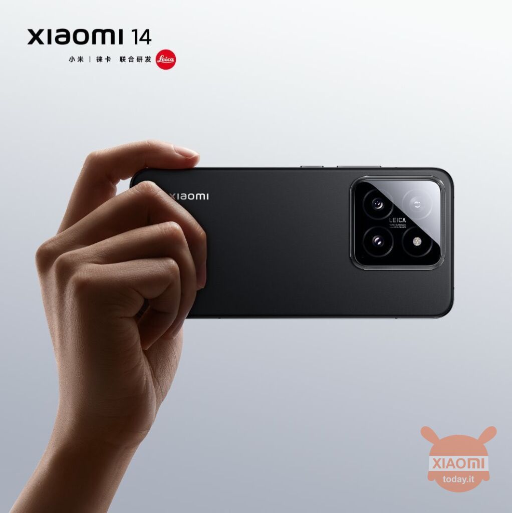 Mano che tiene lo smartphone Xiaomi 14 nero con tripla fotocamera Leica sul retro, su sfondo chiaro. Logo Xiaomi 14 e distintivo Leica in evidenza