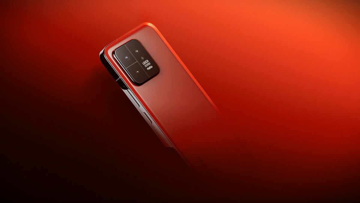 小米 14 智能手机的背面为亮红色。 该手机配备了带有三个镜头的矩形相机模块。 背景是退化的红色，从最暗到最亮的渐变