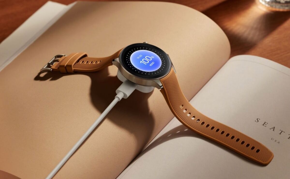 oppo watch x with brown leather-like strap, with charger attached and placed on an open book