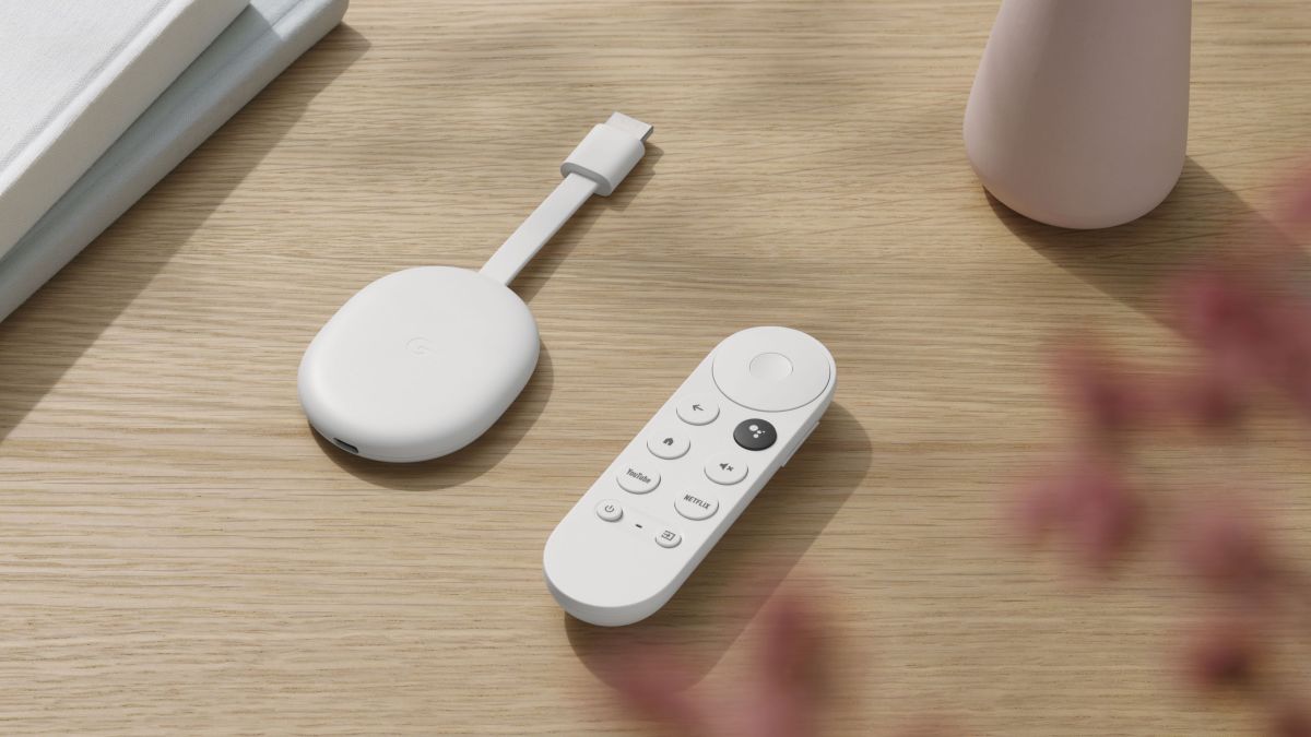 Google Chromecast blanc sur une table en bois avec sa télécommande assortie